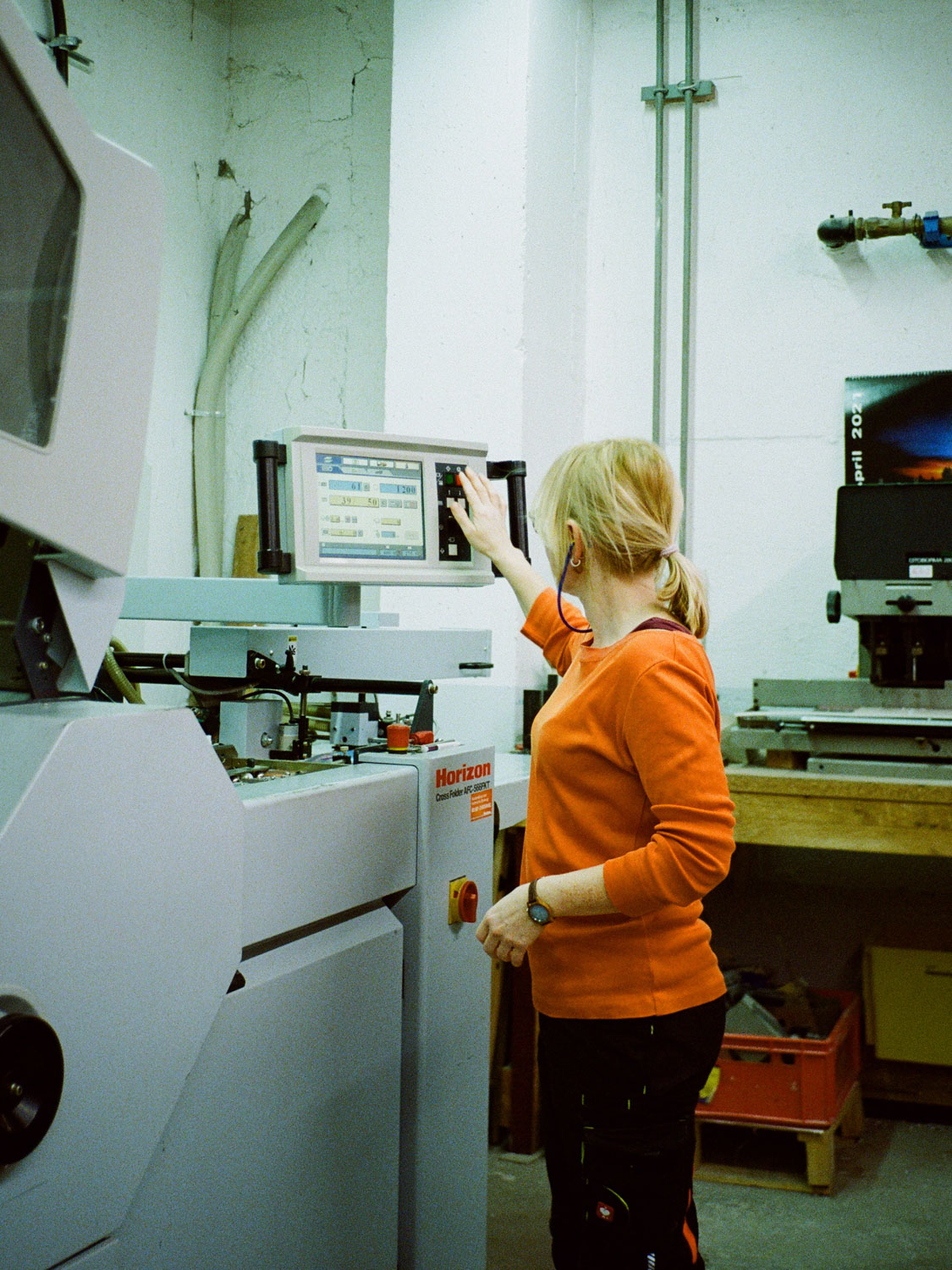 Frau, Oranges Longsleeve, Gehörschutz, Horizon Maschine